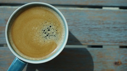 macro view on cup of coffee on wooden table