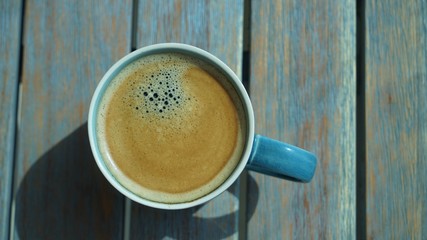 top view on cup of coffee with foam on wooden table