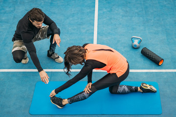 Stretching After Training, Young Woman with Fitness Coach, Outdoors