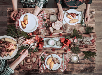 Flat-lay of friends hands eating and drinking together. Top view of people having party, gathering, celebrating together at wooden rustic table