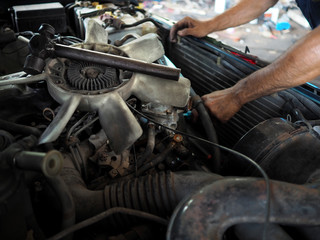 Fototapeta na wymiar Hands of mechanic man in uniform repairing car in garage. Auto repair service.