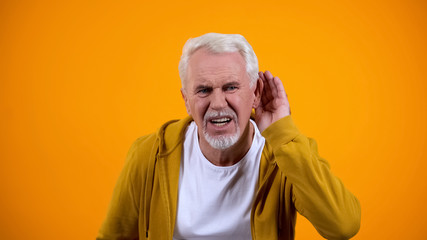 Senior man trying to hear interlocutor, health problems of aged people, deafness