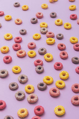 Obraz premium Breakfast cereal rings on purple pink background.