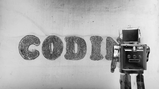 robot writing the word coding on a wall 