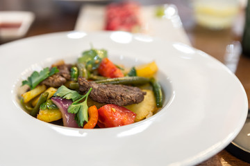 Appetizing salad with beef and vegetables in a white plate.