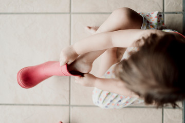 little girl putting her foot in a water boot
