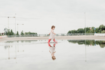 Little girl playing in a puddle, happy. stock photo