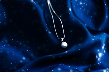 Luxury white gold pearl necklace on dark blue silk, holiday winter magic jewelery present