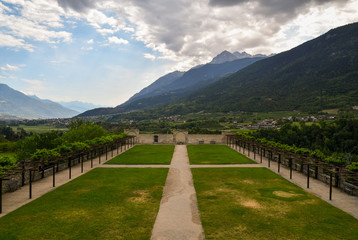 High angle view of the courtyard lawn of the royal castle of Sarre, belonged to the king of Italy Vittorio Emanuele II (1869), with a view on the Alps mountains in summer, Sarre, Aosta Valley, Italy