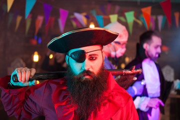 Fototapeta na wymiar Portrait of handsome men dressed up like a sad pirate at halloween gathering