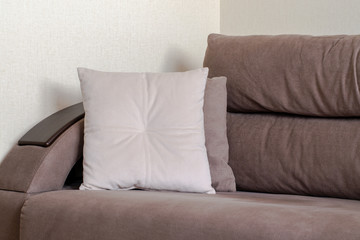 Soft chocolate-colored sofa with pillows. Home cozy furniture