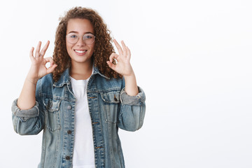 Everything perfect recommend. Attractive curly-haired young freelance girl show approval okay ok gesture smiling pleased agree concept interesting thing idea excellent, delighted white background
