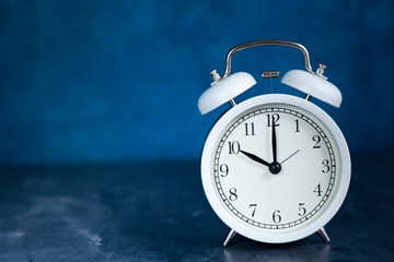 white vintage alarm clock 10:00 o´clock close-up