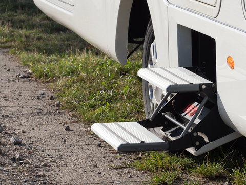 Close view of a twin set of electronic foldaway motor home steps are ready to be used to help enter the vehicle - Image