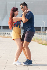 Couple dancing at sunset salsa brazilian zouk. Lovers, dance partners spinning, latin festival dance concept.