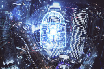 Lock icon hologram on city view with skyscrapers background multi exposure. Data security concept.
