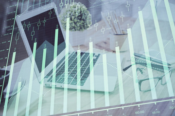 Obraz premium Forex Chart hologram on table with computer background. Multi exposure. Concept of financial markets.