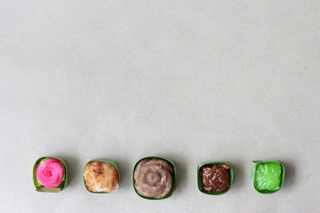 Thai sweets in banana leaves that are arranged on paper background.  Top view image.