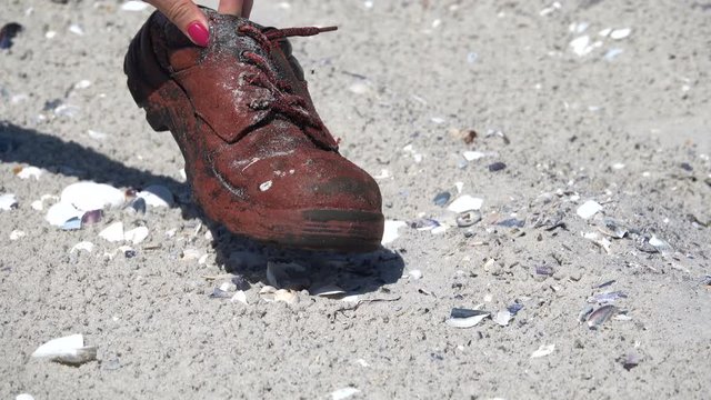 Old boot on the sandy shore of the Black Sea