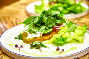 Fried fish with parsley, lettuce, cucumbers and Tartar sauce