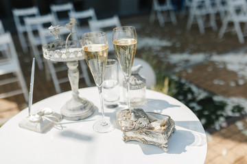 Glasses of champange and wedding rings on the small table