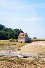 Tide mill of Bugueles in Brittany, France, at low tide on a sunny summer day.
