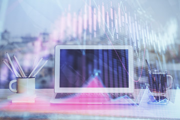 Stock market graph on background with desk and personal computer. Double exposure. Concept of financial analysis.