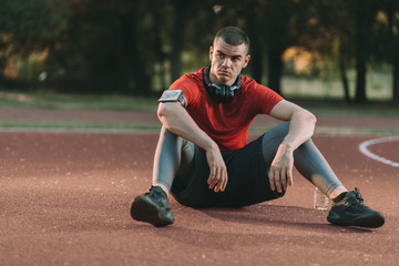 Exhausted athletic man resting after sports training outdoors