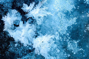 Winter ice background with snow and snowflakes. Natural texture of frozen water. New Year and Christmas card.