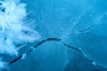 Winter ice background with snow and snowflakes. Natural texture of frozen water. New Year and Christmas card.