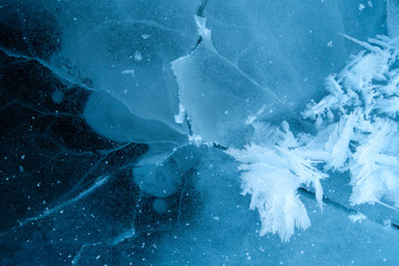 Winter ice background with snow and snowflakes. Natural texture of frozen water. New Year and Christmas card.