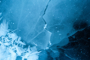 Winter ice background with snow and snowflakes. Natural texture of frozen water. New Year and Christmas card.