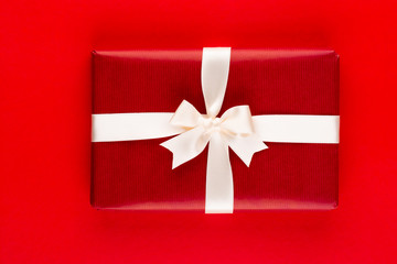 Christmas holiday present box on red background.