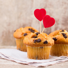 Homemade chocolate muffins with heart, vintage background.