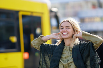 Happy woman in the city with yellow Berlin tramway in the background