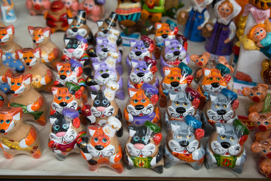 Clay figures painted with bright colors Dogs Cats Foxes Pigs. Selective focus. Folk art is a Decorative art.