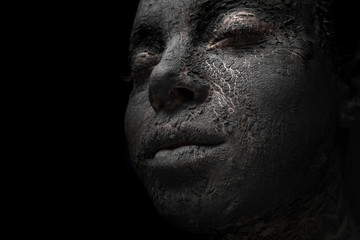  woman face close up with cracked black clay mask