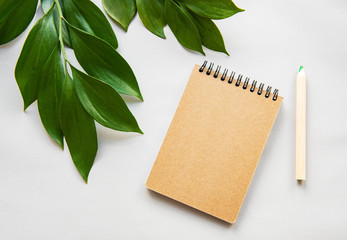 Craft notebook and green leaves