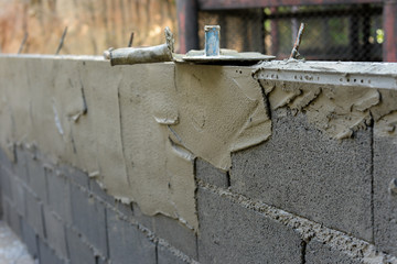 The final step of the wall construction is to spread the cement onto the brick.