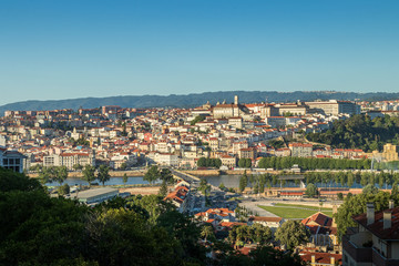 Cityscape of Coimbra in Portugal, from downtown Santa Clara with the Mondego river to the high of Coimbra with the University. At the end of a summer day.