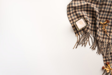Warm scarf and candle, isolated on white background. Flat lay.