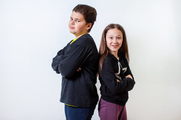 a little girl and a boy stand shoulder to shoulder