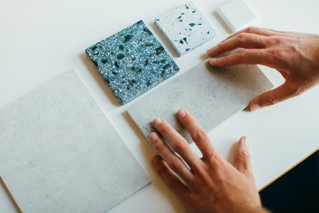 Architect is demonstrating different samples of materials. Hands only.