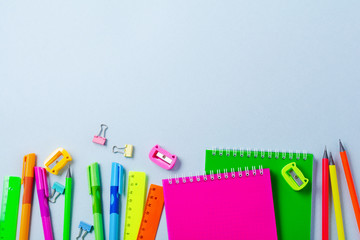 Notebook, colored pencils, ruler, pen, eraser, sharpener and more. School and office stationery on blue background. Concept back to school. Top view.