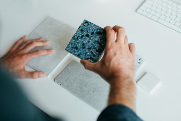 Architect is demonstrating different samples of materials. Hands only.