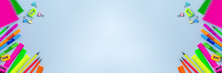 Notebook, colored pencils, ruler, pen, eraser, sharpener and more. School and office stationery on blue background. Banner Concept back to school. Top view.