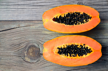 Fresh ripe organic papaya tropical fruit cut in half on old wooden background. Healthy eating,diet or vegan food concept.Copy space.