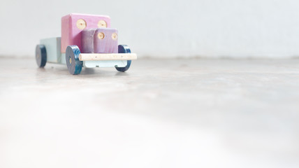 Retro toy car,wooden toy on a light and soft textured background.Selective focus and very shallow depth of field composition.