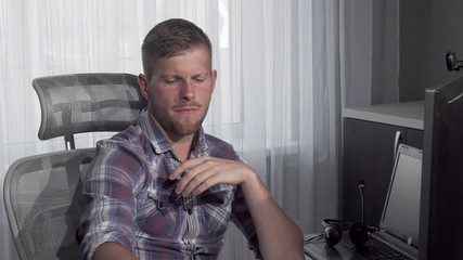 Man eating pizza while working on a project on his computer. Handsome computer programmer eating pizza while working at the office. Freelance, entrepreneurship concept