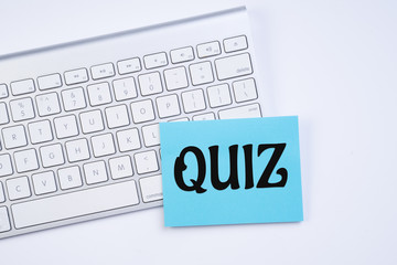 Quiz concept. Quiz word on notepad with keyboard on background. Flay lay